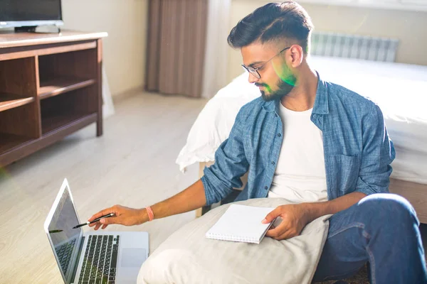 Indischer bärtiger Mann sitzt auf dem Boden und macht finanzielle Berechnungen Online-Geschäft in neuer Wohnung — Stockfoto