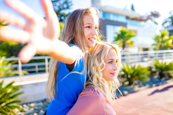 Smiling mother and beautiful daughter having fun on the beach — Stock Photo, Image