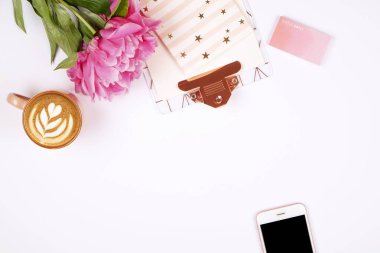 Kadının office masaüstü ile pembe şakayık çiçekleri buketi, cappuccino kahve, boş ekran Mobil cep telefonu, akıllı telefon, kalem, bardak sağlar. Latte sanat, arka plan düz lay, kopyalama alanı, yakın çekim