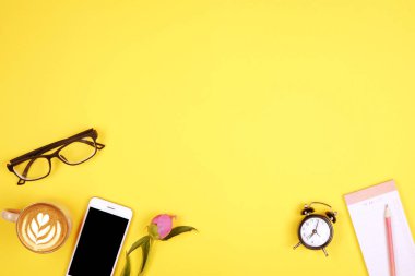 Kadının masa düz yatıyordu kompozisyon. Danışma kaynakları, boş ekran cep telefonu, kahve fincanı, Gözlük, tertipçi-e doğru liste, boş onay kutusunu, yapmak, w / mini alarm saat. Son Tarih kavramı kopya alanı, sarı arka plan