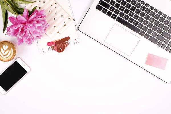 Kız gibi office masaüstü siyah ve beyaz dizüstü klavye, pembe şakayık çiçekleri buketi, kahve, boş ekran Mobil cep telefonu, akıllı telefon, kalem, bardak ile sağlar. Arka plan düz yerde kal, kopya alanı, yakın çekim