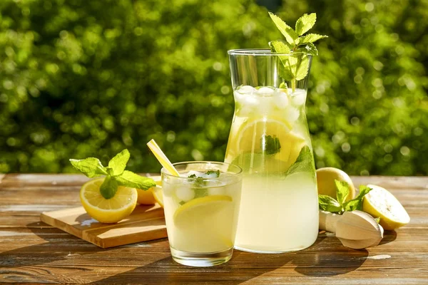 Eisgekühlte Limonadenkanne Saftpresse Und Ein Glas Kaltes Zitrusgetränk Mit Zitronenscheiben — Stockfoto