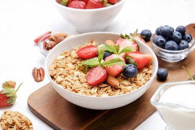 Yayınlama seçeneğini granola kase fındık, tahıl, meyve ve çilek, Yunan yoğurt karışımı ile. Sağlıklı vejetaryen kahvaltı, organik çilek, yaban mersini, nane, badem. Yakın çekim, görünümü, arka plan top.