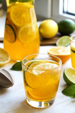 Buzlu limonata sürahi ve iki bardak, ahşap meyve sıkacağı, soğuk narenciye infüzyon su, limon ve limon, nane yaprakları, kesme tahtası üzerinde beyaz ahşap pencere. Daire pencere arka plan, yakın çekim, kopya alanı.