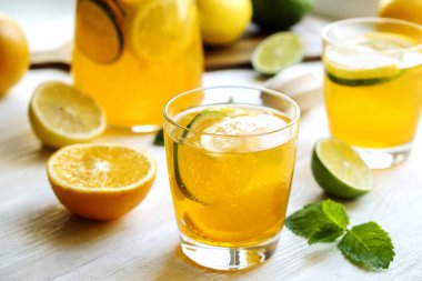 Buzlu limonata sürahi ve iki bardak, ahşap meyve sıkacağı, soğuk narenciye infüzyon su, limon ve limon, nane yaprakları, kesme tahtası üzerinde beyaz ahşap pencere. Daire pencere arka plan, yakın çekim, kopya alanı.
