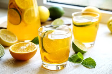 Buzlu limonata sürahi ve iki bardak, ahşap meyve sıkacağı, soğuk narenciye infüzyon su, limon ve limon, nane yaprakları, kesme tahtası üzerinde beyaz ahşap pencere. Daire pencere arka plan, yakın çekim, kopya alanı.