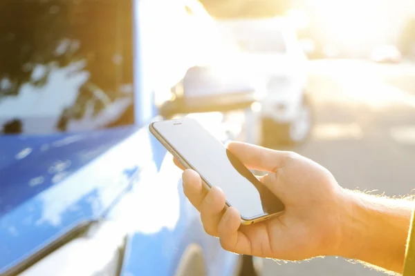 スマート フォンを使用して立っている シャツ黄色彼新しいカリブ海の青い車の近くで若い男 男性の手で空白の画面携帯電話を保持します Gps ナビゲーションの概念 クローズ アップ コピー スペース — ストック写真