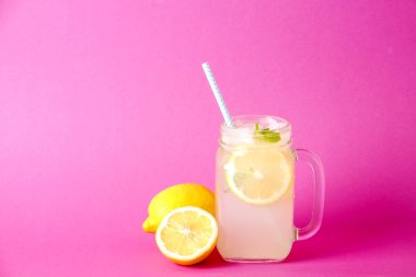Soğuk lavanta limonata, limon, saman, nane Ice. Klasik bakire mojito kokteyl, alkolsüz içki vintage mason kavanoza cam buz ile parlak pembe arka plan izole. Alan, kopyalama en iyi görünümü Kapat.