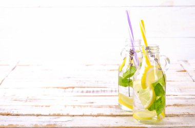 Buz soğuk lavanta limonata, limon, saman. İki klasik bakire mojito içecekler, Alkolsüz kokteyl ile buz grunged ahşap zemin üzerine iki vintage hipster şişelerde. Alan, kopyalama en iyi görünümü Kapat.