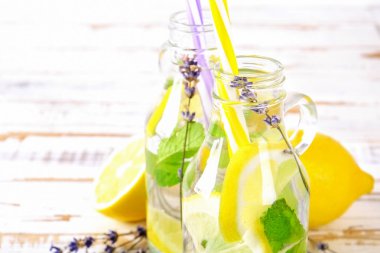 Buz soğuk lavanta limonata, limon, saman. İki klasik bakire mojito içecekler, Alkolsüz kokteyl ile buz grunged ahşap zemin üzerine iki vintage hipster şişelerde. Alan, kopyalama en iyi görünümü Kapat.