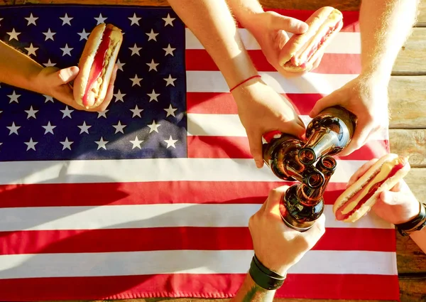 4th of July celebration party, young men hands holding beer bottle, holiday label design, Happy Independence day, hot dog, mustard, catchup. American flag, river recreation area. Close up, background