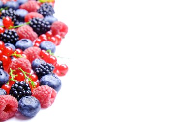 Hasat yığın beyaz zemin üzerine karışık meyveli demet. Taze organik çilek, yaban mersini, böğürtlen ve somun ile renkli kompozisyon. Temiz kavramı yeme. Yakın çekim, uzay, üstten görünüm Kopyala