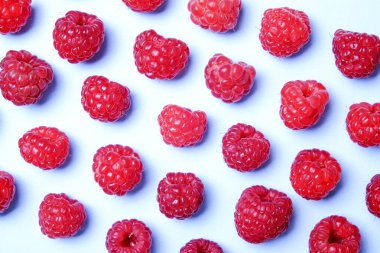 Taze organik ahududu meyveleri sorunsuz süsleme desen, beyaz arka plan avuç. Temiz kavramı yeme. Sağlıklı besleyici vejeteryan yemek, lezzetli pişmemiş yiyecek. Yakın çekim, kopya alanı, üstten görünüm, düz lay.