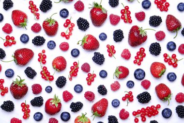 Hasat yığın beyaz zemin üzerine karışık meyveli demet. Taze organik çilek, yaban mersini, böğürtlen ve somun ile renkli kompozisyon. Temiz kavramı yeme. Yakın çekim, uzay, üstten görünüm Kopyala