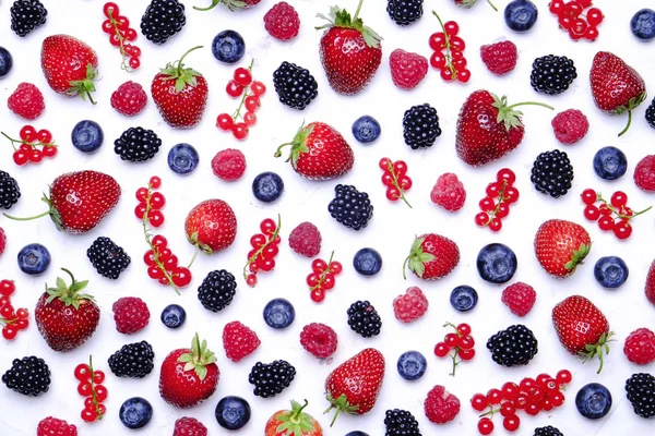 Hasat yığın beyaz zemin üzerine karışık meyveli demet. Taze organik çilek, yaban mersini, böğürtlen ve somun ile renkli kompozisyon. Temiz kavramı yeme. Yakın çekim, uzay, üstten görünüm Kopyala