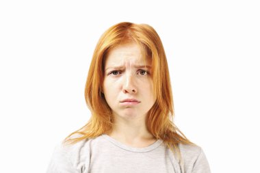 Portre kaşlarını çattı kaşlarını ve sefil bir görünüm ile sızlanan Kızıl saçlı beyaz genç kadın, hayal kırıklığına yüz ifadesi, kapatın. Çocukça üzgün yüz güzel kadın var. Arka plan beyaz, yakın çekim.