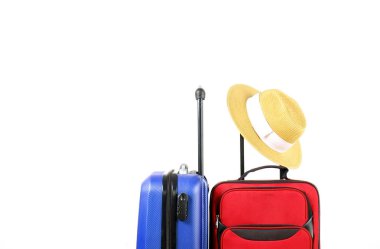 Kırmızı tekstil çanta ve mavi sert kabuklu Bagaj ile hasır şapka asılı teleskop sapı, beyaz dekoratif doku duvar arka plan genişletilmiş. Çiftler yolculuk kavramı çekilmek. Yakın çekim, alanı Kopyala.