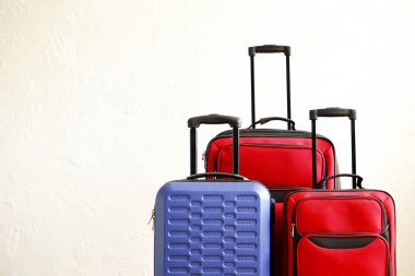Farklı üç bavul, büyük ve küçük, kırmızı Tekstil ve mavi sert kabuklu Bagaj genişletilmiş Teleskopik Saplı boyutu. Aile gezisi kavramı. Alan, beyaz duvar arka plan kopyalayın. Tam dolu Bagaj.