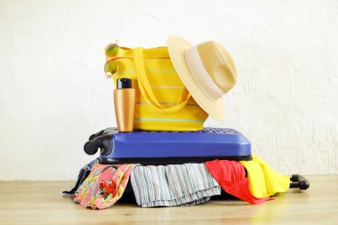 İn yakın elbise yapışkanlık dışarı şeyler dağınık tam dolu kapalı çantada uygun değil. Mavi sert kabuklu Bagaj. Plaj çanta, şapka, güneş gözlüğü. Kadın tatil kavramı için ambalaj. Alan arka plan kopyalama