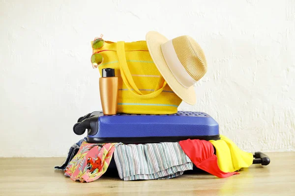 İn yakın elbise yapışkanlık dışarı şeyler dağınık tam dolu kapalı çantada uygun değil. Mavi sert kabuklu Bagaj. Plaj çanta, şapka, güneş gözlüğü. Kadın tatil kavramı için ambalaj. Alan arka plan kopyalama