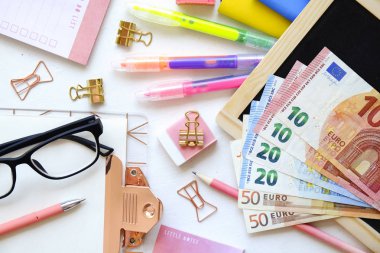 Avrupa'nın maliyeti pahalı açmak istiyorum. Euro banknot farklı mezhepleri, boş Pano, renkli kalem, okul malzemeleri, tablet gadget, gözlük. Arka plan, düz yatıyordu, yakın, kopya alanı.