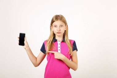 Uzun doğal sarı saçları, boş ekran cep telefonu işaret parmağı ile rahat genç yaş kız portresi. Smartphone holding, görüntü gösterilen unamused genç erkek. Beyaz arka plan, kopya alanı