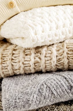 Bir sürü örülmüş pastel renkli süveter farklı örgü desenleri yığılmış, açıkça görülebilen doku. Şık sonbahar / kış mevsimi örgü giysileri. Kapat, metin için boşluk kopyala.