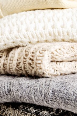 Bir sürü örülmüş pastel renkli süveter farklı örgü desenleri yığılmış, açıkça görülebilen doku. Şık sonbahar / kış mevsimi örgü giysileri. Kapat, metin için boşluk kopyala.