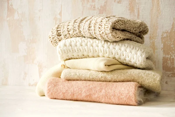 따뜻한 파스텔 스웨터 테이블 Grunged 배경에 지저분한 스택에 뜨개질 클로즈업 — 스톡 사진