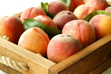 Olgun demet taze organik şeftali yığınının çiftçi pazar içinde ahşap tepsi aldı. Şeftali hasat yığın. Sağlıklı vegan ham Aperatif. Temiz kavramı yeme. Kırpılmış shot, arka plan, üstten görünüm, düz yatıyordu.