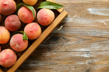 Olgun organik şeftali grunged Ahşap dokulu masa üzerinde ip kulplu ahşap tepsi tepsi üzerinde yığın demet. Yerli malı hasat yığın. Temiz kavramı yeme. Arka plan, görünümü top, yakın çekim, alanı Kopyala