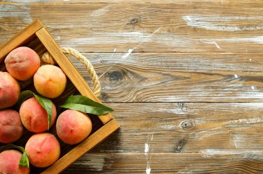 Olgun organik şeftali grunged Ahşap dokulu masa üzerinde ip kulplu ahşap tepsi tepsi üzerinde yığın demet. Yerli malı hasat yığın. Temiz kavramı yeme. Arka plan, görünümü top, yakın çekim, alanı Kopyala