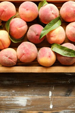 Olgun organik şeftali grunged Ahşap dokulu masa üzerinde ip kulplu ahşap tepsi üzerinde yığın demet. Yerli malı hasat yığın. Temiz kavramı yeme. Arka plan, görünümü top, yakın çekim, alanı Kopyala