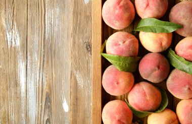 Olgun organik şeftali grunged Ahşap dokulu masa üzerinde ip kulplu ahşap tepsi üzerinde yığın demet. Yerli malı hasat yığın. Temiz kavramı yeme. Arka plan, görünümü top, yakın çekim, alanı Kopyala