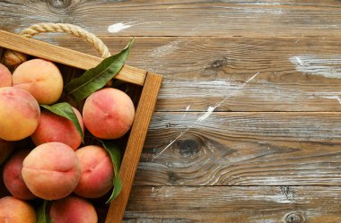 Olgun organik şeftali grunged Ahşap dokulu masa üzerinde ip kulplu ahşap tepsi üzerinde yığın demet. Yerli malı hasat yığın. Temiz kavramı yeme. Arka plan, görünümü top, yakın çekim, alanı Kopyala