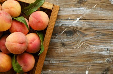 Olgun organik şeftali grunged Ahşap dokulu masa üzerinde ip kulplu ahşap tepsi üzerinde yığın demet. Yerli malı hasat yığın. Temiz kavramı yeme. Arka plan, görünümü top, yakın çekim, alanı Kopyala