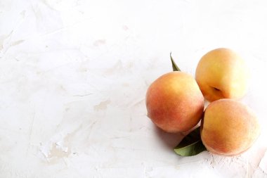 Beyaz ahşap dokulu masa üzerinde ip kulplu ahşap tepsi tepsi üzerinde yığın olgun organik şeftali demet. Yerli malı hasat yığın. Temiz kavramı yeme. Arka plan, görünümü top, yakın çekim, alanı Kopyala.