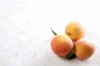 Beyaz ahşap dokulu masa üzerinde ip kulplu ahşap tepsi tepsi üzerinde yığın olgun organik şeftali demet. Yerli malı hasat yığın. Temiz kavramı yeme. Arka plan, görünümü top, yakın çekim, alanı Kopyala.