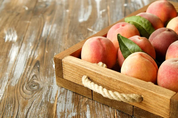 Olgun organik şeftali grunged Ahşap dokulu masa üzerinde ip kulplu ahşap tepsi üzerinde yığın demet. Yerli malı hasat yığın. Temiz kavramı yeme. Arka plan, görünümü top, yakın çekim, alanı Kopyala