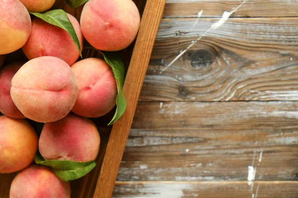 Olgun organik şeftali grunged Ahşap dokulu masa üzerinde ip kulplu ahşap tepsi üzerinde yığın demet. Yerli malı hasat yığın. Temiz kavramı yeme. Arka plan, görünümü top, yakın çekim, alanı Kopyala
