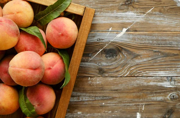 Olgun organik şeftali grunged Ahşap dokulu masa üzerinde ip kulplu ahşap tepsi üzerinde yığın demet. Yerli malı hasat yığın. Temiz kavramı yeme. Arka plan, görünümü top, yakın çekim, alanı Kopyala