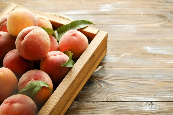 Olgun organik şeftali grunged Ahşap dokulu masa üzerinde ip kulplu ahşap tepsi üzerinde yığın demet. Yerli malı hasat yığın. Temiz kavramı yeme. Arka plan, görünümü top, yakın çekim, alanı Kopyala