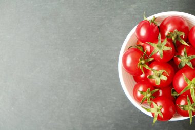 Beyaz seramik kase dolu taze koyu gri kayrak taş üzerine, görünür doku küçük olgun organik kiraz domates aldım. Temiz kavramı yeme. Yerli malı. Arka plan, uzay kopyalayın, yakın çekim, görünümü ana sayfa.