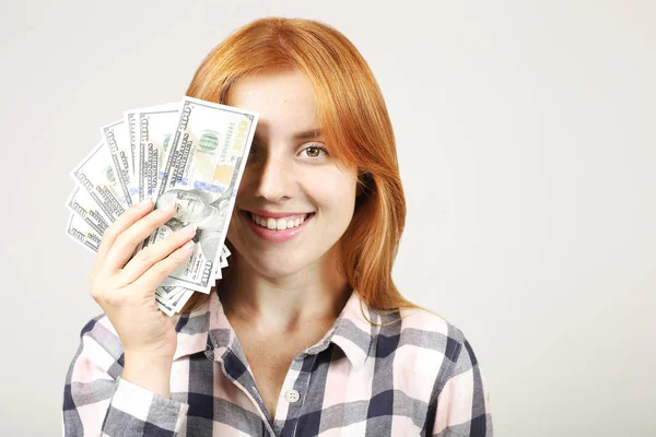年轻漂亮的红发女人用大把的钱捂住脸 捧着一堆100美元的钞票 像个粉丝 兴奋有吸引力的女性与大量的现金 复制空间 — 图库照片