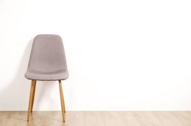 Boş odada, büyük boş duvar arka plan ahşap zemin üzerinde tek başına duran tek zarif gri loft tarzı sandalye. Metin için büyük kopya yer. Sadece bir boş koltuk. İnsan kaynakları kampanya kavramı işe.