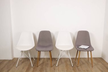 Birden çok loft tarzı boş sandalye ahşap zemin, danışmanının koltuk Pano ve notlar için kalem satırındaki ayakta. Grup terapisi için bağımlıları ve alkolikler konsept danışmanlık. Alan arka plan kopya, yakın çekim