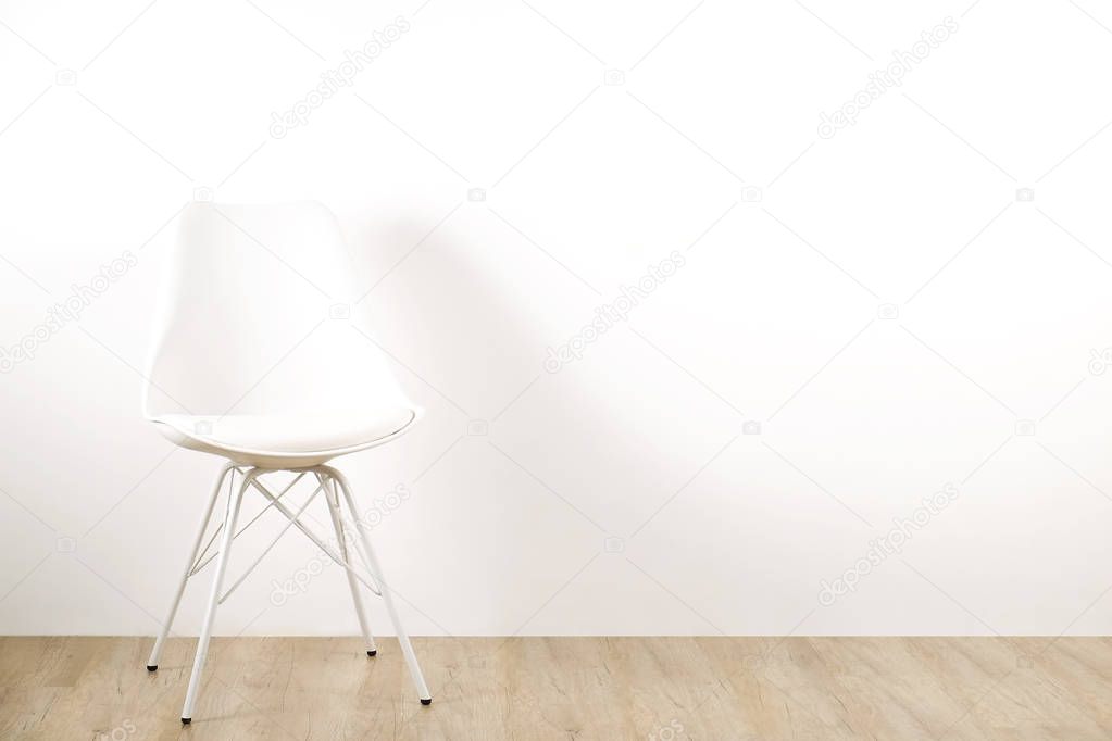 Single elegant white loft style chair standing alone on wooden floor in empty room, big blank wall background. Large copy space for text. Only one vacant seat. Human resources hiring campaign concept.