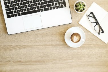 Minimalist düz kompozisyon ile siyah ve beyaz dizüstü bilgisayar klavye, kahve ile kalp şekli latte sanat ahşap Resepsiyon arka plan üzerinde yatıyordu. Yakın çekim, görünümü, kopya alanı top. Yaratıcı çalışma alanı.