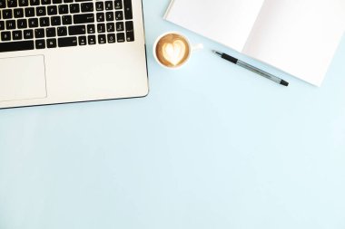 Minimalist düz mavi yüzey Resepsiyon Masa arka plan üzerinde siyah ve beyaz dizüstü bilgisayar klavye, cep telefonu, kahve fincanı, boş sayfa defter kompozisyon yatıyordu. Çalışma alanı üstten görünüm, kopya alanı.