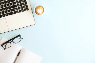Siyah ve beyaz dizüstü bilgisayar klavye minimalist düz yatıyordu kompozisyon, fincan kahve ve katlanmış gözlük, boş sayfaları defter, kalem, Resepsiyon Masa arka plan mavi. Çalışma alanı üstten görünüm, kopya alanı